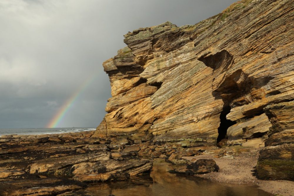 Sandstone cliffs; Moray coast; rainbow; dramatic sky